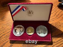 En français, le titre serait : Ensemble commémoratif de 3 pièces en or et en argent des Jeux olympiques de 1983 et 1984, épreuve de qualité.